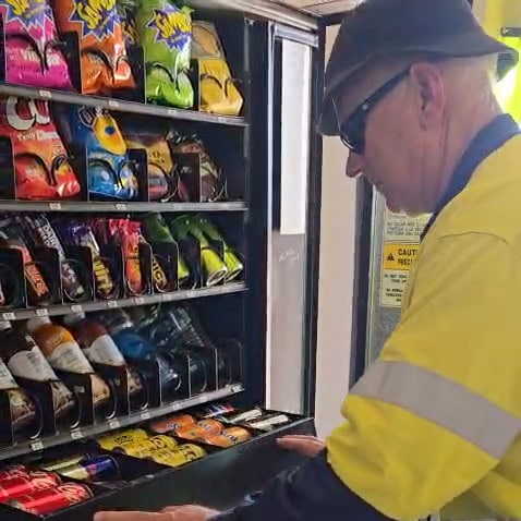 A1 Vending operator restocking a snack and drink vending machine as part of a vending machine service WA.