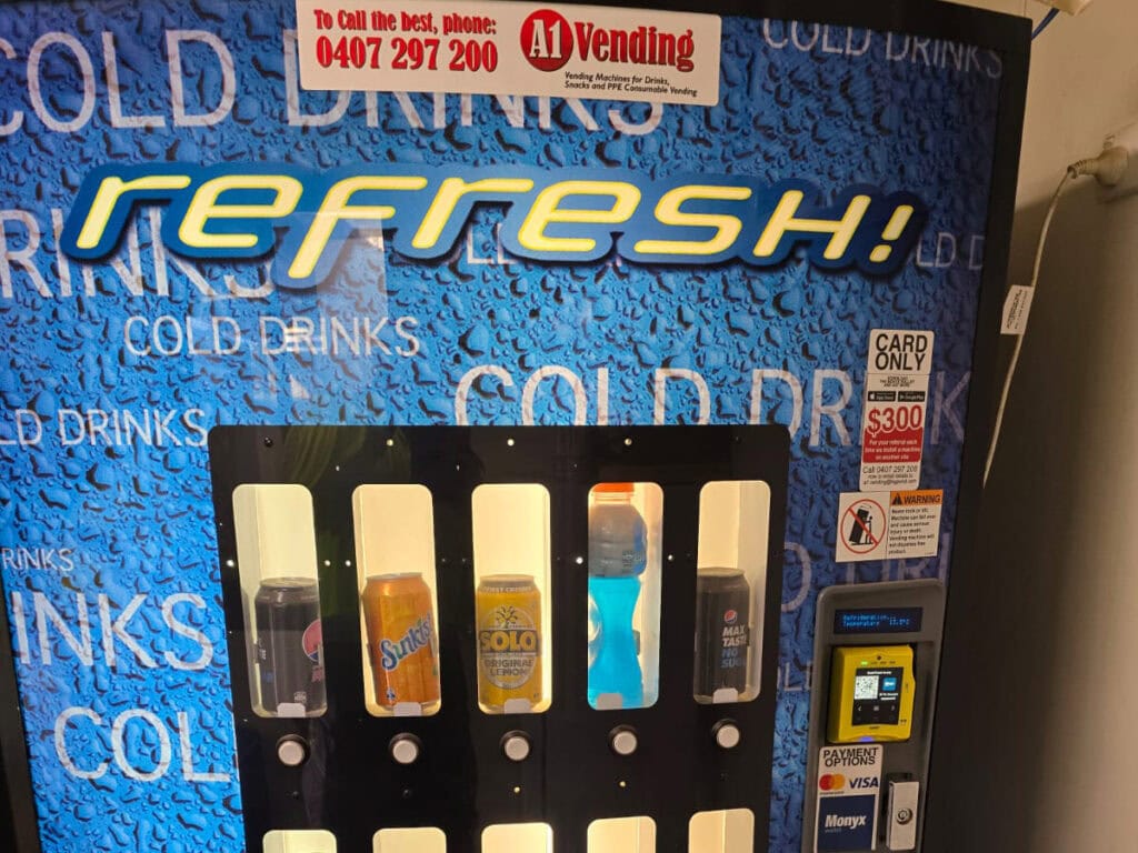 Worker using tap-and-go contactless payment on a vending machine - cashless vending machines WA worksites rely on