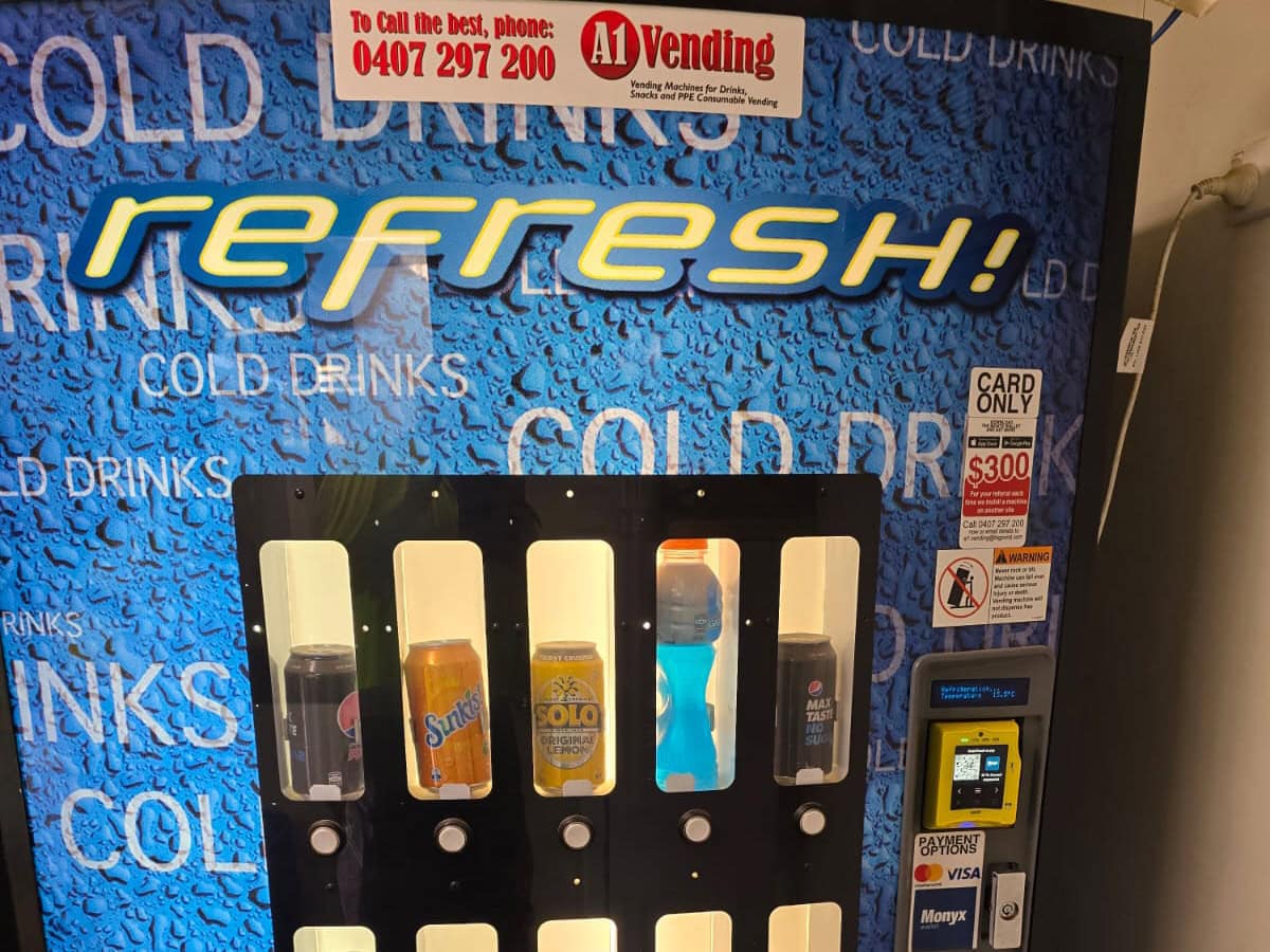 Worker using tap-and-go contactless payment on a vending machine - cashless vending machines WA worksites rely on